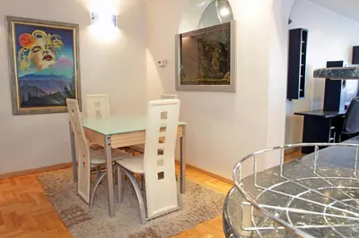 a dining room with a glass table and chairs at Belgrade Republic Square Apartment in Belgrade