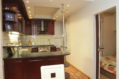 a kitchen with wooden cabinets and a counter top at Belgrade Republic Square Apartment in Belgrade