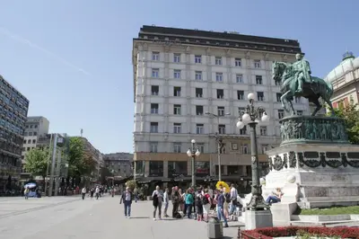 a group of people walking in a city with a statue at Belgrade Republic Square Apartment in Belgrade