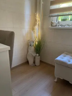 a white teddy bear sitting in a room with a plant at Vanja in Čukarica