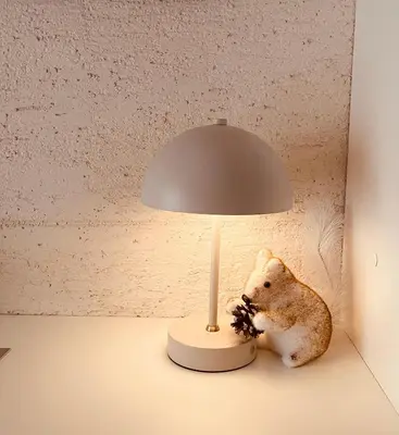 a lamp on a table with a stuffed animal under it at Vanja in Čukarica