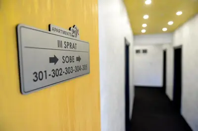 a sign on a wall in a hallway at Apartments 29 in Inđija
