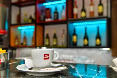 a cup of coffee sitting on a counter in a bar at Apartments 29 in Inđija