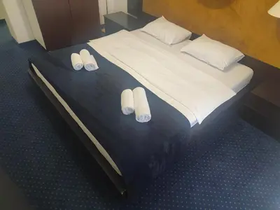 a bed with two pairs of slippers on it at Apartments 29 in Inđija