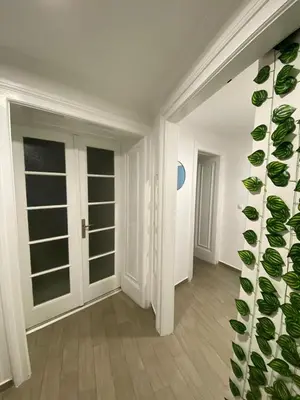 an empty room with a hallway with glass doors at Lana apartman in Belgrade