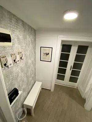 a living room with a bench and a wall at Lana apartman in Belgrade