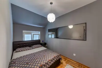 a bedroom with a bed and a large mirror at Nobless in Belgrade