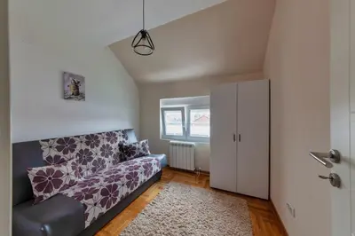 a living room with a couch and a window at Nobless in Belgrade