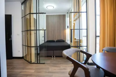 a room with a bed and a table and chairs at Suite Music in Batajnica