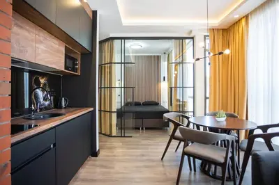 a kitchen with a table and a dining room at Suite Music in Batajnica