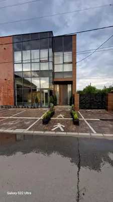 a large glass building with a star in a parking lot at Suite Music in Batajnica
