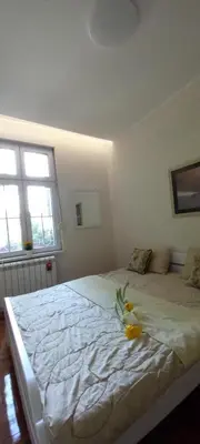 a bedroom with a bed with a flower on it at APARTMAN KRUNA in Belgrade