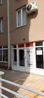 a facade of a building with a door and a fan at TPC 9 in Žarkovo