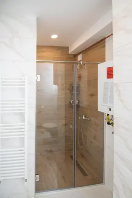 a shower with a glass door in a bathroom at Hemingway LUX in Arandjelovac