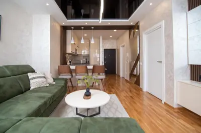 a living room with a green couch and a table at Hemingway LUX in Arandjelovac
