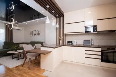 a kitchen and living room with a table and chairs at Hemingway LUX in Arandjelovac