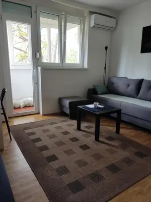 a living room with a couch and a coffee table at Quiet city center oasis - In the shade of walnut in Belgrade