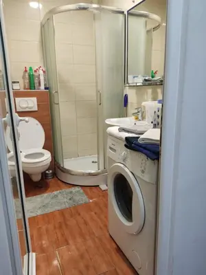 a bathroom with a washing machine and a toilet at Quiet city center oasis - In the shade of walnut in Belgrade