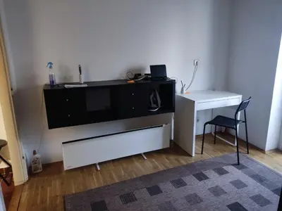 a living room with a tv and a desk at Quiet city center oasis - In the shade of walnut in Belgrade