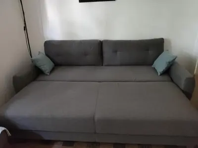 a couch with two pillows on it in a room at Quiet city center oasis - In the shade of walnut in Belgrade