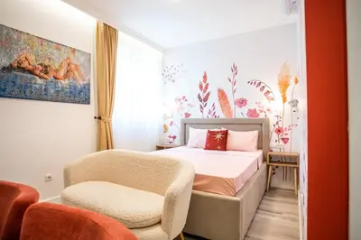 a bedroom with a bed and a chair at Coral Studio in Batajnica