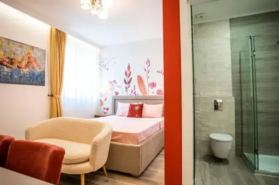 a bedroom with a bed and a glass shower at Coral Studio in Batajnica
