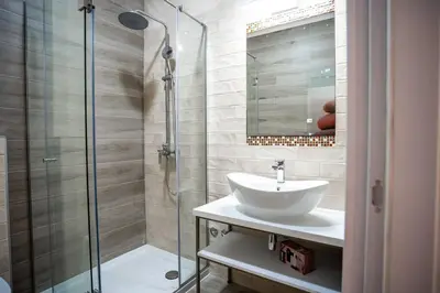 a bathroom with a sink and a glass shower at Coral Studio in Batajnica