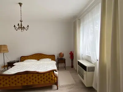 a bedroom with a bed and a chandelier at Apartman Ema in Ruma