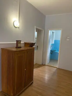 an empty room with a wooden cabinet and a bathroom at Apartman Ema in Ruma