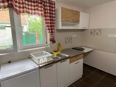 a small kitchen with a sink and a window at Apartman Ema in Ruma