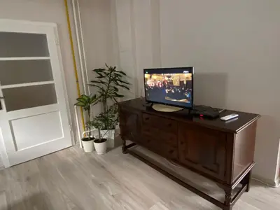 a living room with a television on a wooden dresser at Apartman Ema in Ruma
