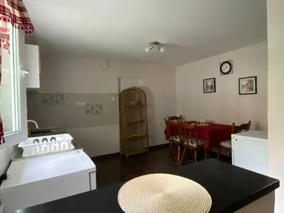 a kitchen with a white stove and a table at Apartman Ema in Ruma