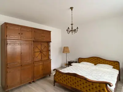 a bedroom with a bed and a large wooden cabinet at Apartman Ema in Ruma