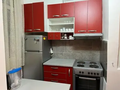 a small kitchen with red cabinets and a stove at Sara in Zvezdara