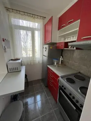 a small kitchen with red cabinets and a stove at Sara in Zvezdara