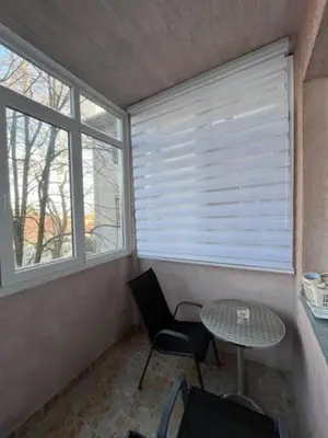 a room with a table and a table and two windows at Sara in Zvezdara