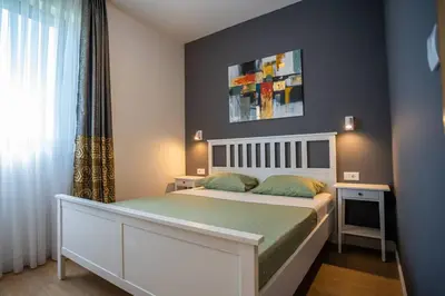 a bedroom with a large bed and a window at The boy next door apartment in Batajnica