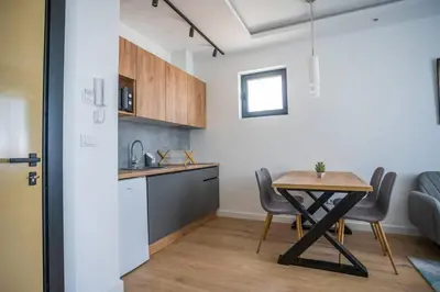 a kitchen and dining room with a table and chairs at The boy next door apartment in Batajnica