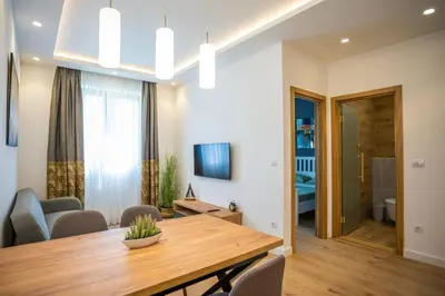 a dining room and living room with a wooden table at The boy next door apartment in Batajnica