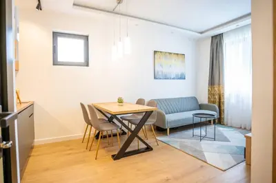 a kitchen and dining room with a table and chairs at The boy next door apartment in Batajnica