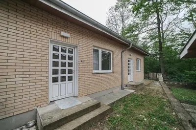 a small brick house with a white door and stairs at Cvrkut Ptica - Mladenovac in Mladenovac