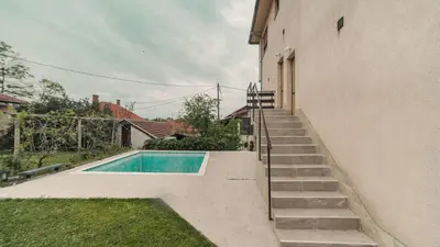 a swimming pool with stairs next to a building at Cvrkut Ptica - Mladenovac in Mladenovac