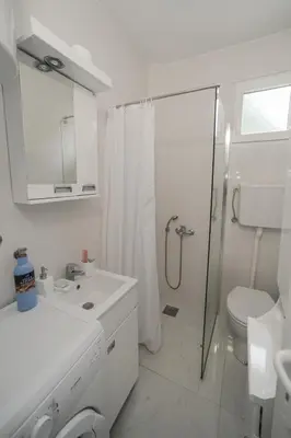 a white bathroom with a shower and a toilet at Cvrkut Ptica - Mladenovac in Mladenovac