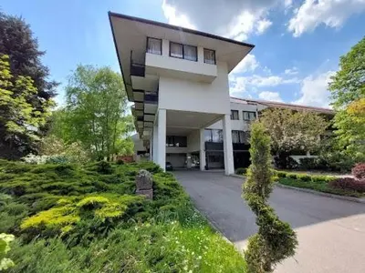 a large white building with a lot of bushes and trees at Cvrkut Ptica - Mladenovac in Mladenovac
