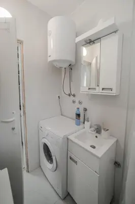 a white laundry room with a washing machine and a sink at Cvrkut Ptica - Mladenovac in Mladenovac