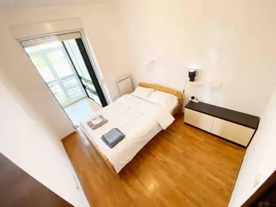 a small bedroom with a bed and a window at Azzaro apartment with two bedrooms in Bežanija