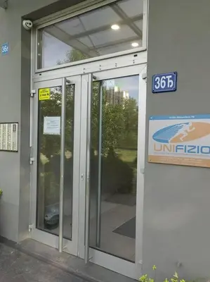 a glass door of a building with a sign on it at Azzaro apartment with two bedrooms in Bežanija
