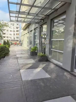 a building with windows and plants on a sidewalk at Azzaro apartment with two bedrooms in Bežanija