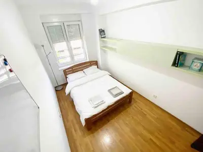 a small bedroom with a bed and a window at Azzaro apartment with two bedrooms in Bežanija