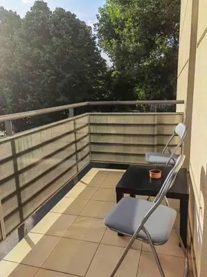a balcony with a table and chairs on a balcony at Azzaro apartment with two bedrooms in Bežanija